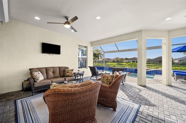 view of patio featuring a lanai, ceiling fan, and an outdoor hangout area