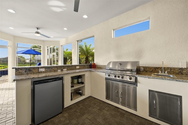 view of patio with ceiling fan, sink, and grilling area