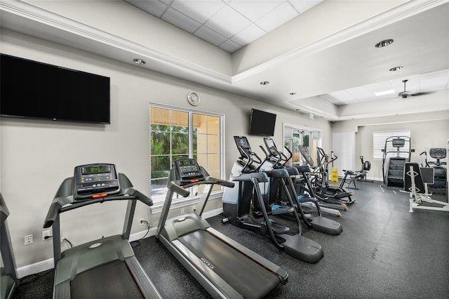 exercise room featuring a tray ceiling and plenty of natural light