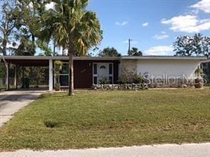 view of front of home with a front yard and a carport