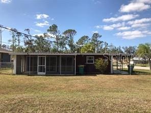 back of house with a lawn and a sunroom