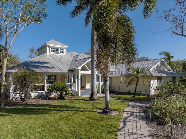 12510 Coconut Creek Ct, Fort Myers, FL 33908 - view of front of property featuring metal roof, a porch, a front lawn, and a standing seam roof