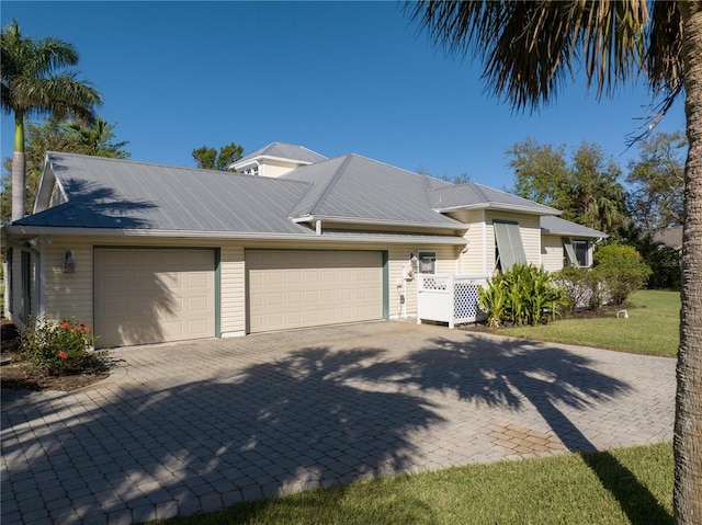 12510 Coconut Creek Ct, Fort Myers, FL 33908 - view of front of house with an attached garage, decorative driveway, and metal roof
