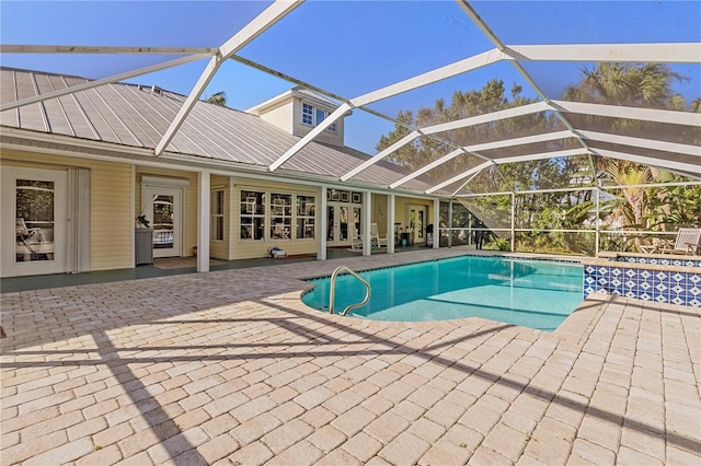 view of pool with glass enclosure and a patio area