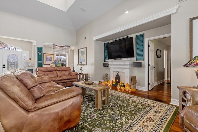 12510 Coconut Creek Ct, Fort Myers, FL 33908 - living room featuring wood finished floors, a warm lit fireplace, baseboards, and a towering ceiling