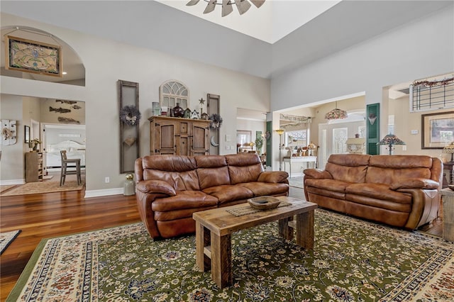 12510 Coconut Creek Ct, Fort Myers, FL 33908 - living room with a towering ceiling, wood finished floors, arched walkways, ceiling fan, and baseboards