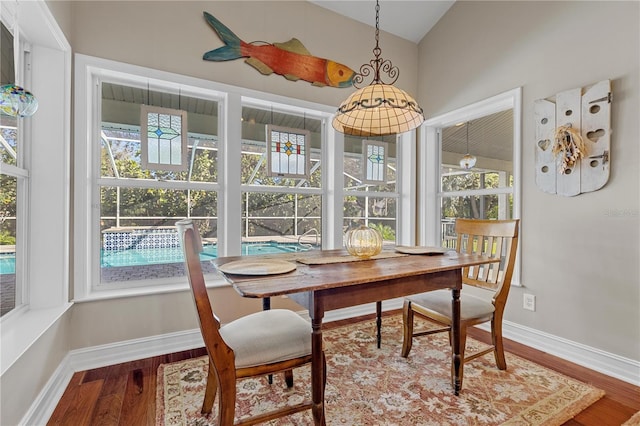 12510 Coconut Creek Ct, Fort Myers, FL 33908 - dining room with wood finished floors, baseboards, and vaulted ceiling