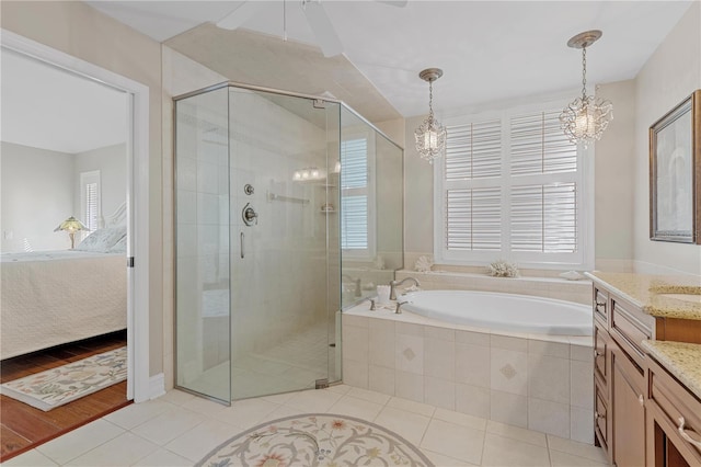 bathroom with tile patterned flooring, vanity, independent shower and bath, and a chandelier