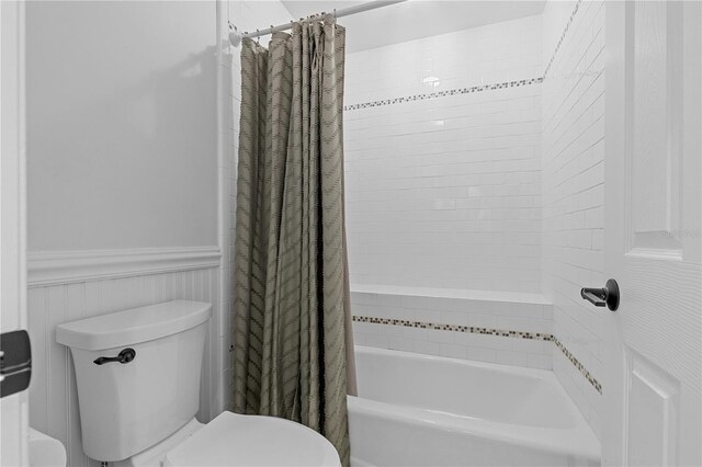 12510 Coconut Creek Ct, Fort Myers, FL 33908 - full bath with toilet, wainscoting, and shower / bathtub combination with curtain