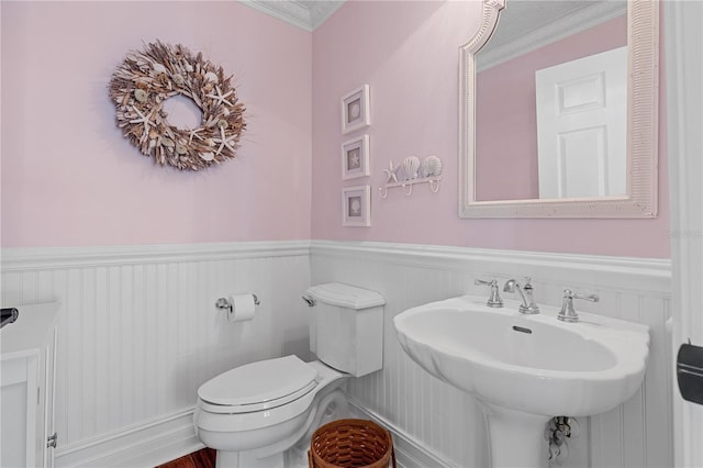 bathroom with sink, toilet, and ornamental molding