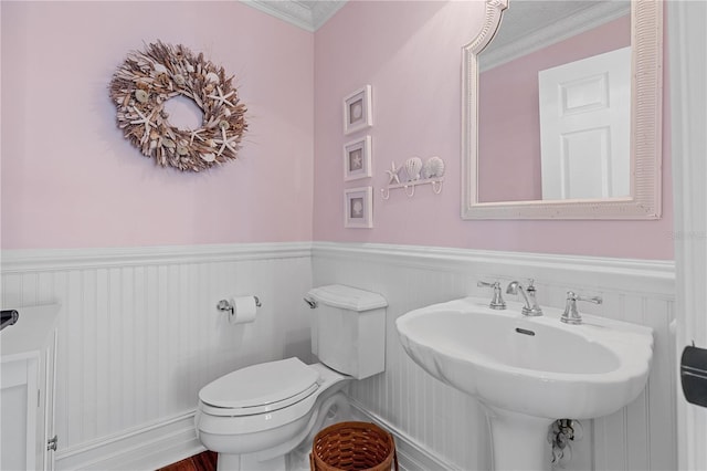 12510 Coconut Creek Ct, Fort Myers, FL 33908 - bathroom featuring a wainscoted wall, toilet, crown molding, and a sink
