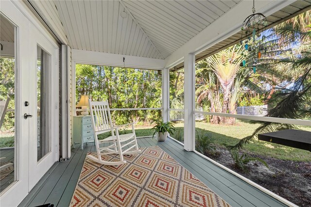 sunroom / solarium featuring a wealth of natural light, wooden ceiling, and vaulted ceiling