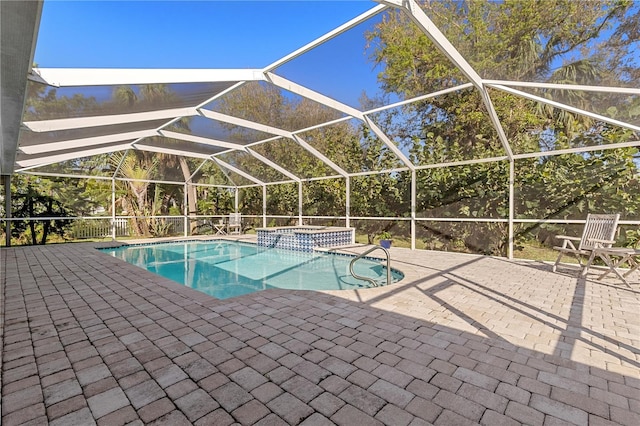 view of pool with a lanai, a patio area, and an in ground hot tub