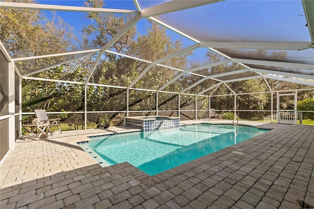 view of pool with an in ground hot tub, glass enclosure, and a patio area