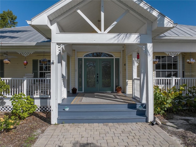 view of exterior entry featuring a porch and french doors