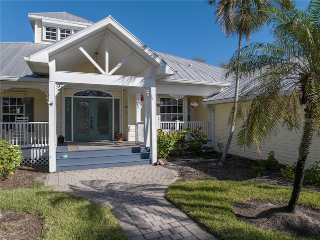 entrance to property with french doors and a porch