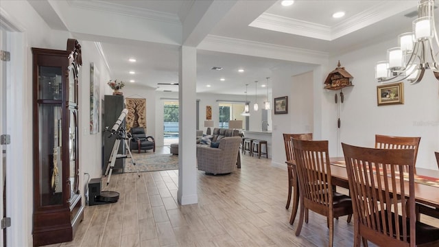 dining space with crown molding, light hardwood / wood-style flooring, and ceiling fan with notable chandelier