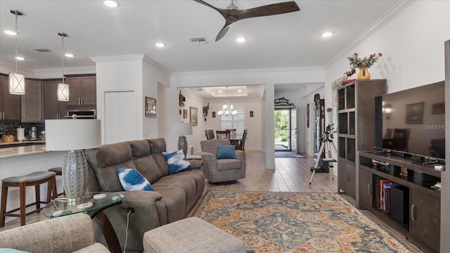 living room featuring hardwood / wood-style floors, ceiling fan with notable chandelier, and crown molding