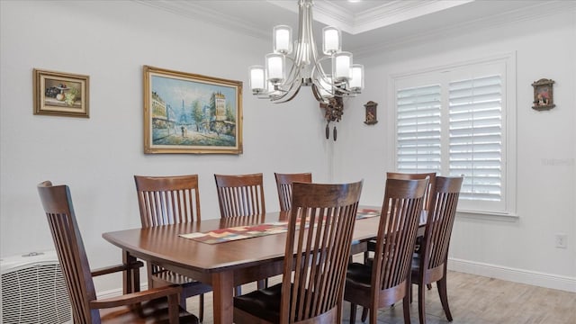 dining space with a notable chandelier, plenty of natural light, light wood-type flooring, and ornamental molding