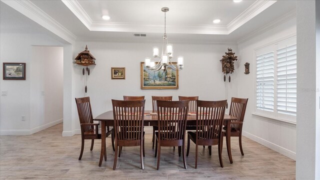 dining area featuring a healthy amount of sunlight, crown molding, and a tray ceiling