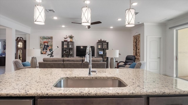 kitchen with light stone countertops, hanging light fixtures, and ornamental molding