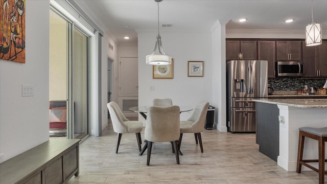 dining space with ornamental molding