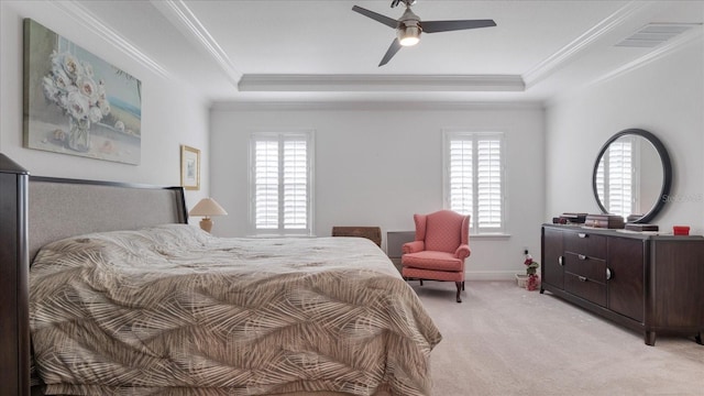 bedroom featuring ceiling fan, crown molding, light carpet, and a tray ceiling