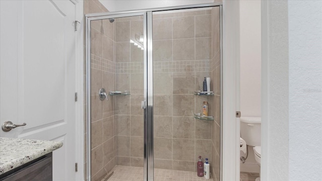 bathroom with vanity, an enclosed shower, and toilet