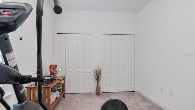 interior space featuring light carpet and multiple closets