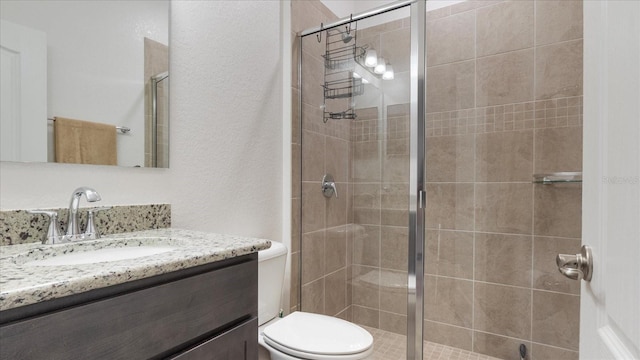 bathroom with vanity, toilet, and a shower with shower door