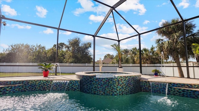 view of pool with glass enclosure, pool water feature, and an in ground hot tub