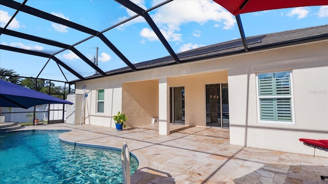 view of pool with a patio area and glass enclosure