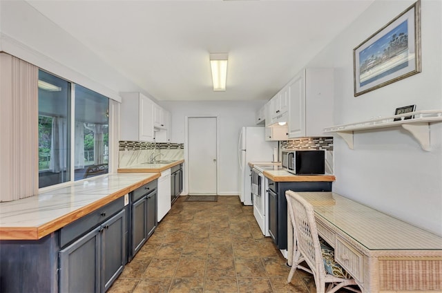 kitchen with wooden counters, sink, white cabinetry, white appliances, and decorative backsplash