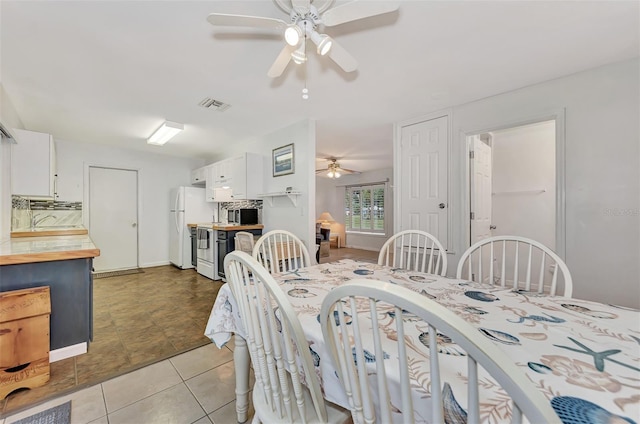 tiled dining area with ceiling fan