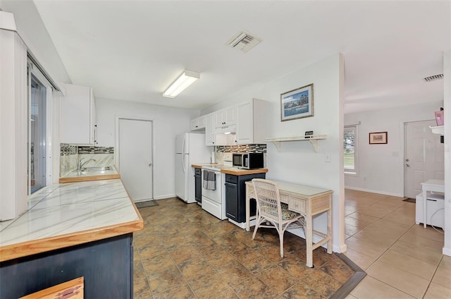 kitchen with white cabinetry, white appliances, and tasteful backsplash