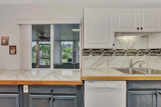 kitchen featuring dishwasher, decorative backsplash, white cabinets, sink, and ceiling fan