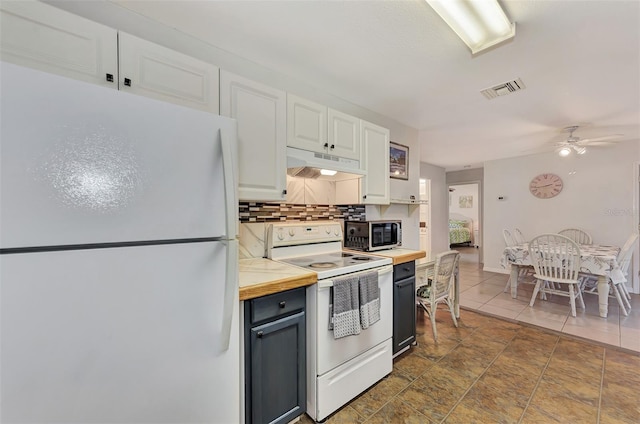 kitchen featuring ceiling fan, white appliances, dark tile patterned floors, white cabinets, and backsplash