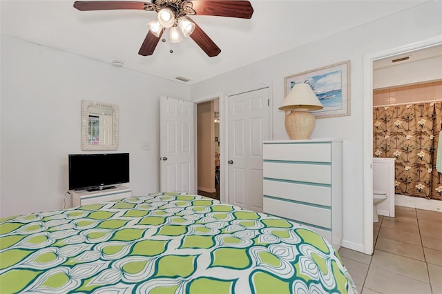 unfurnished bedroom featuring ceiling fan, ensuite bathroom, and light tile patterned floors