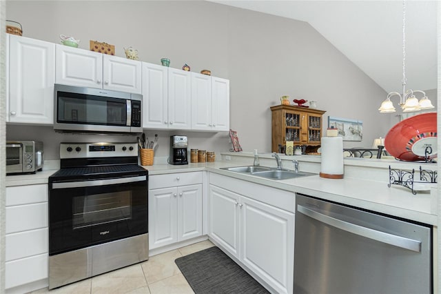 kitchen featuring sink, kitchen peninsula, vaulted ceiling, white cabinets, and appliances with stainless steel finishes