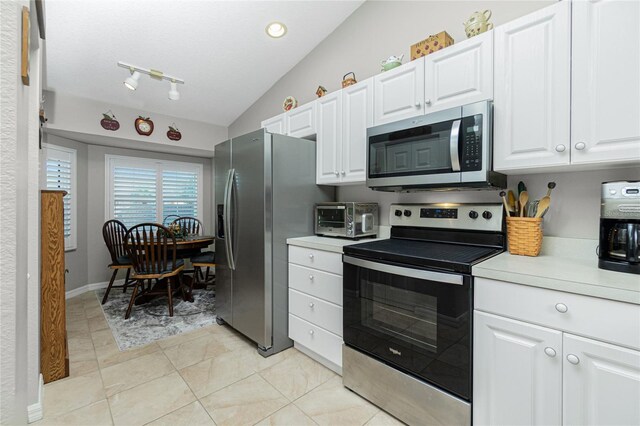 kitchen featuring white cabinets, stainless steel appliances, and lofted ceiling