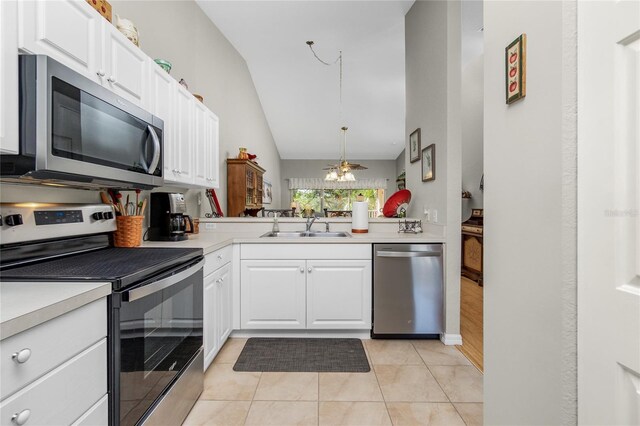 kitchen featuring sink, white cabinets, lofted ceiling, and appliances with stainless steel finishes