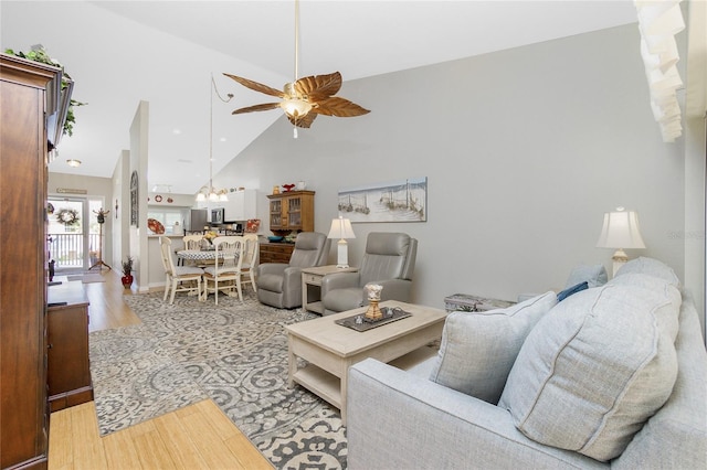 living room featuring ceiling fan, light hardwood / wood-style floors, and high vaulted ceiling