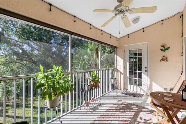 unfurnished sunroom featuring ceiling fan