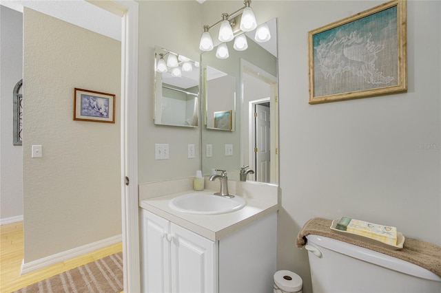 bathroom with vanity, hardwood / wood-style flooring, and toilet