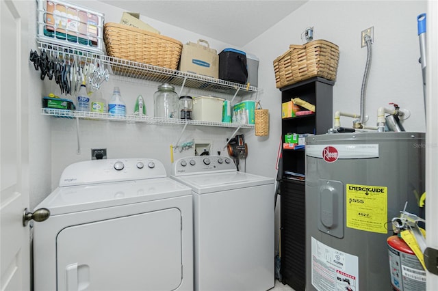 clothes washing area featuring water heater and washer and clothes dryer