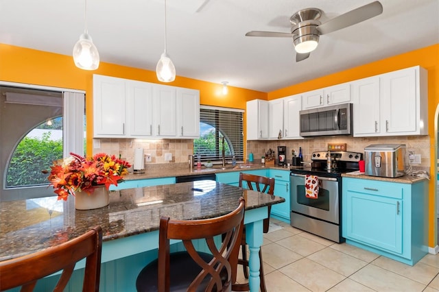 kitchen featuring blue cabinetry, ceiling fan, stainless steel appliances, pendant lighting, and white cabinets