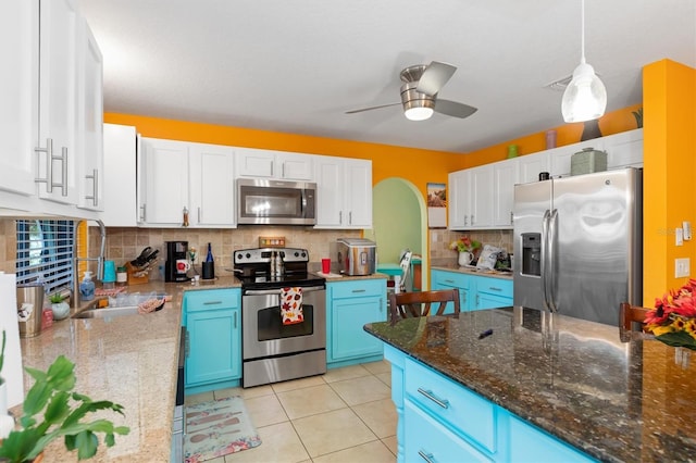 kitchen with ceiling fan, hanging light fixtures, stainless steel appliances, blue cabinets, and white cabinets