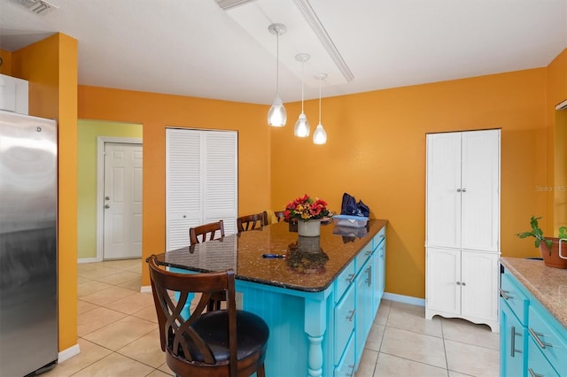 4290 Randypaar St, Port Charlotte, FL 33948 - kitchen featuring freestanding refrigerator, blue cabinets, light tile patterned floors, and a kitchen bar