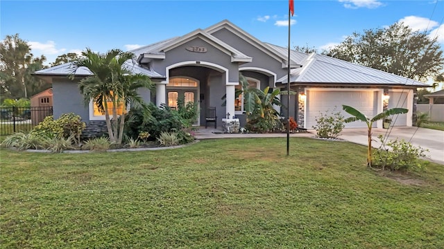 view of front of house with a front lawn, a garage, and french doors