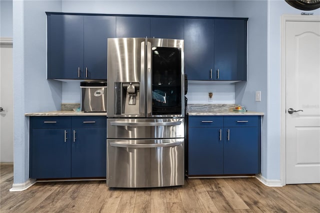 kitchen featuring light hardwood / wood-style floors, stainless steel refrigerator with ice dispenser, and blue cabinets